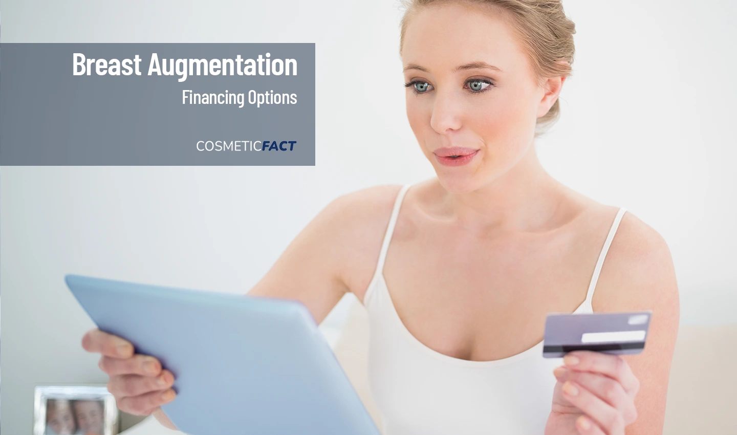 Woman calculating breast augmentation financing options with a credit card in hand.
