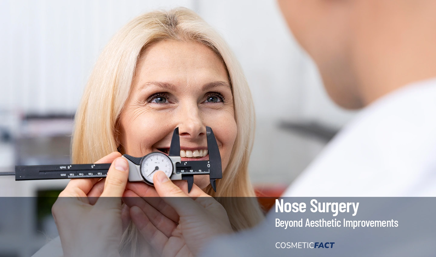A woman smiling during a rhinoplasty consultation while a plastic surgeon measures her nose width to explore the medical benefits of nose reshaping.