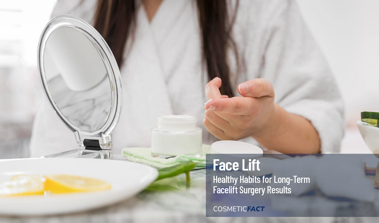 A young woman applies cream to her face to maintain the results of her facelift surgery.