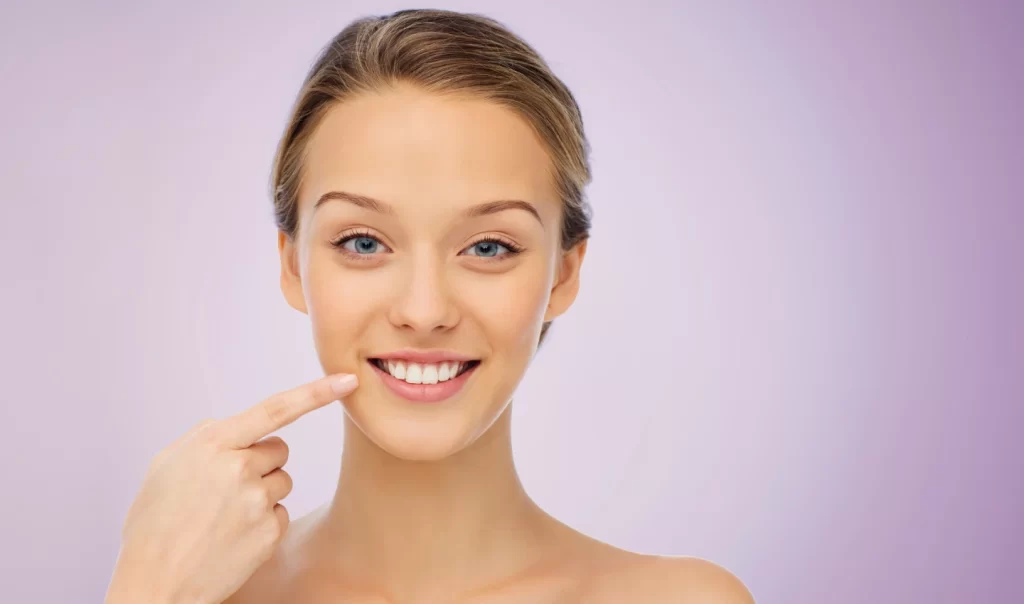 A beautiful woman smiling and showing off her healthy, radiant lips, representing the importance of lip care tips for achieving a luscious smile.