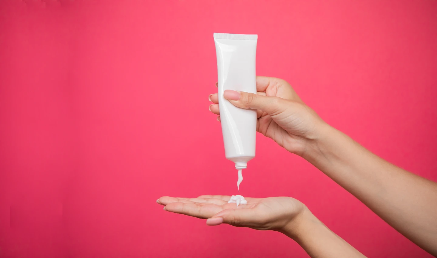 Woman pumping dry skin moisturiser onto her hand.