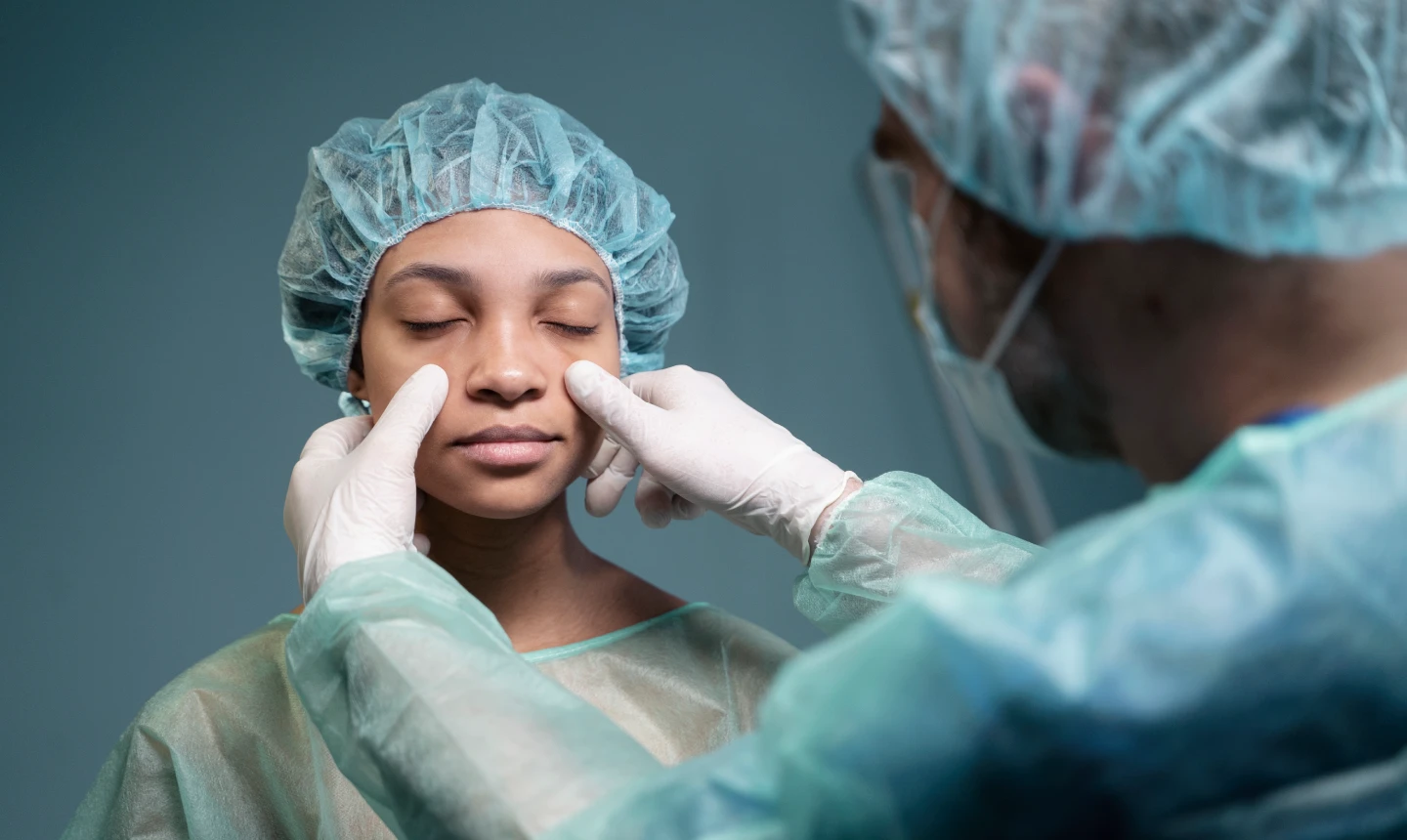 A black woman sitting in a surgeon's office, discussing pros and cons of combining facelift surgery and nose surgery procedures.