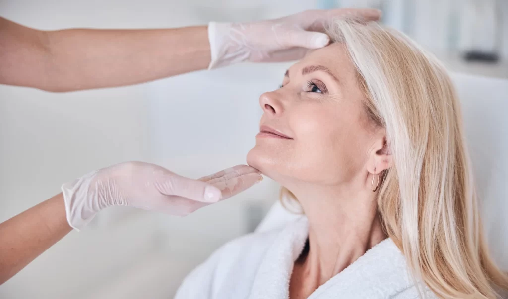 Mature woman being examined by a dermatologist after age spot removal treatment.