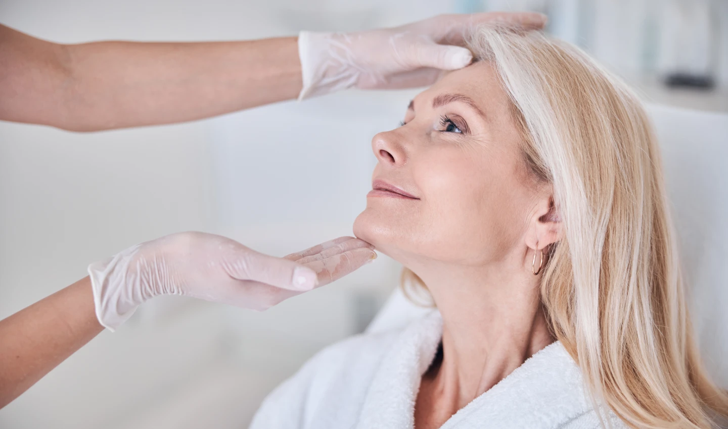 Mature woman being examined by a dermatologist after age spot removal treatment.