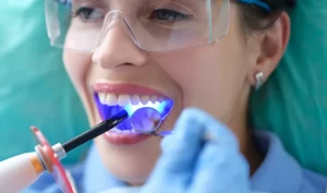 Two doctors examining a patient's teeth during a consultation for teeth beauty surgery.