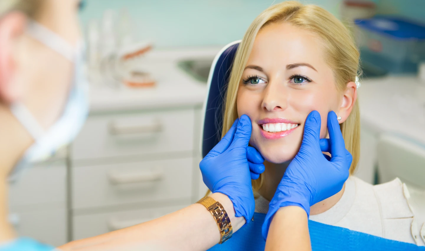 A dentist examines a patient's smile after post-operative care cosmetic dental surgery.