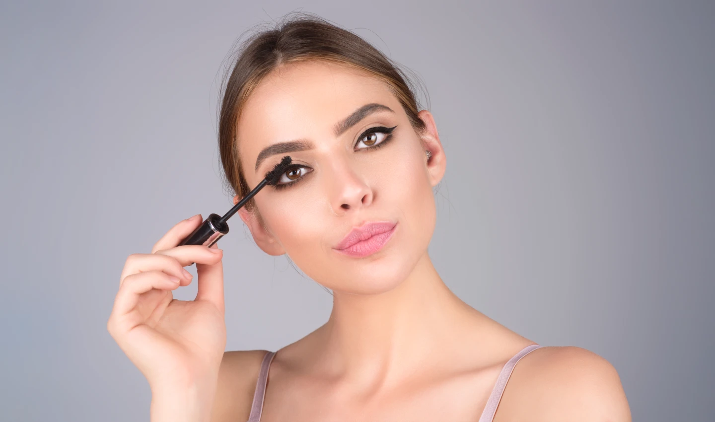 : A woman wearing lengthening mascara that gives her extraordinary lash length, creating dramatic eyes.