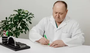 A doctor writing down the cost of hair cosmetic surgery for a patient in a clinic.