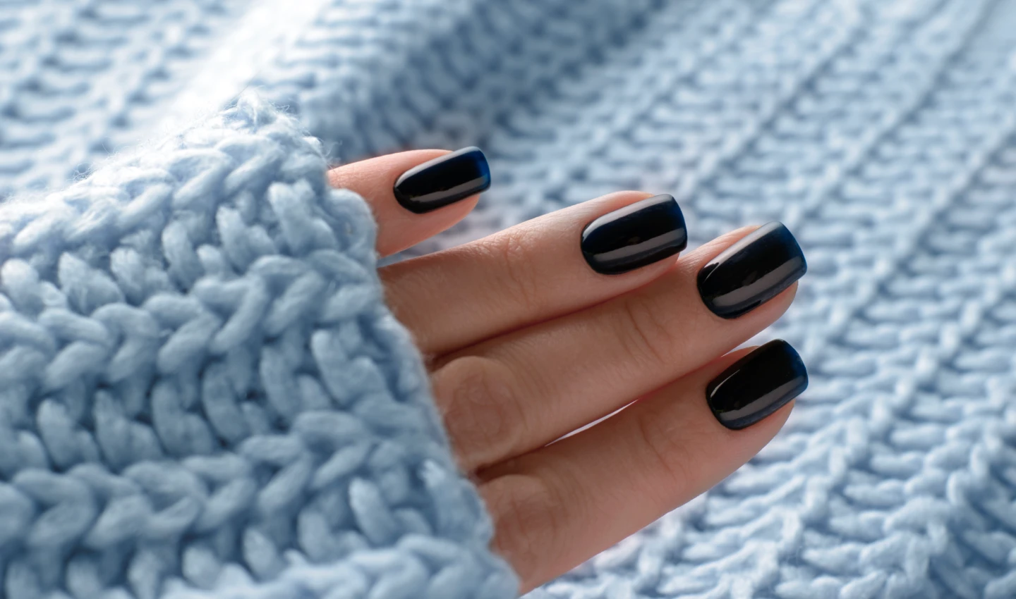 A hand with beautifully manicured nails, showcasing the results of a long-lasting manicure.