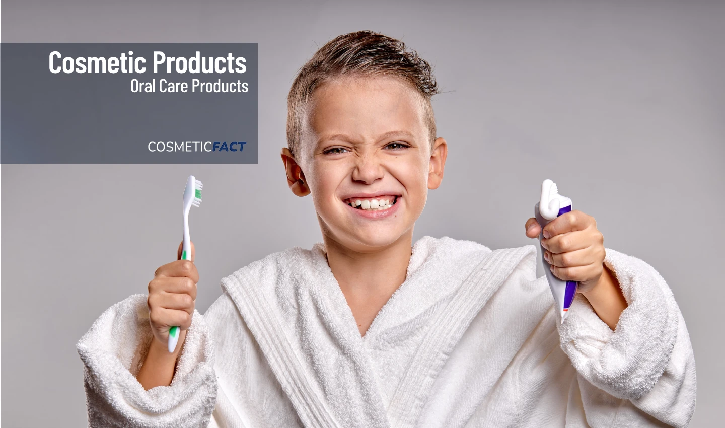 A smiling young boy holds his toothpaste and toothbrush, showcasing the importance of Kids' Oral Care in maintaining healthy teeth and gums.