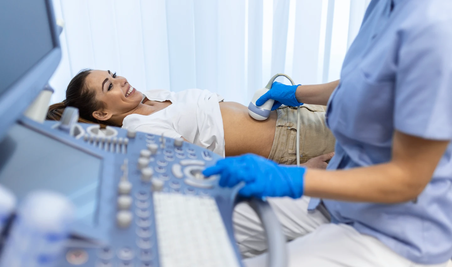 A doctor uses ultrasound therapy on a patient's abdomen to reduce fat and reshape their body, as discussed in the article "From CoolSculpting to Ultrasound Therapy: Which Non-Surgical Body Treatments Are Right for You?