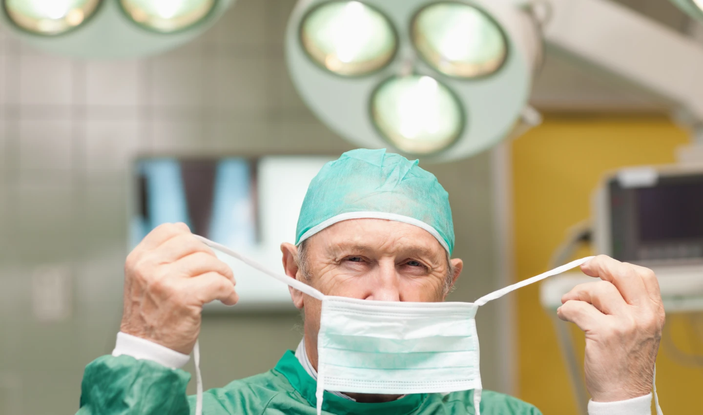 A doctor in surgical scrubs prepares for a body beauty surgery procedure, underscoring the significance of proper regulation in safeguarding patients' safety.