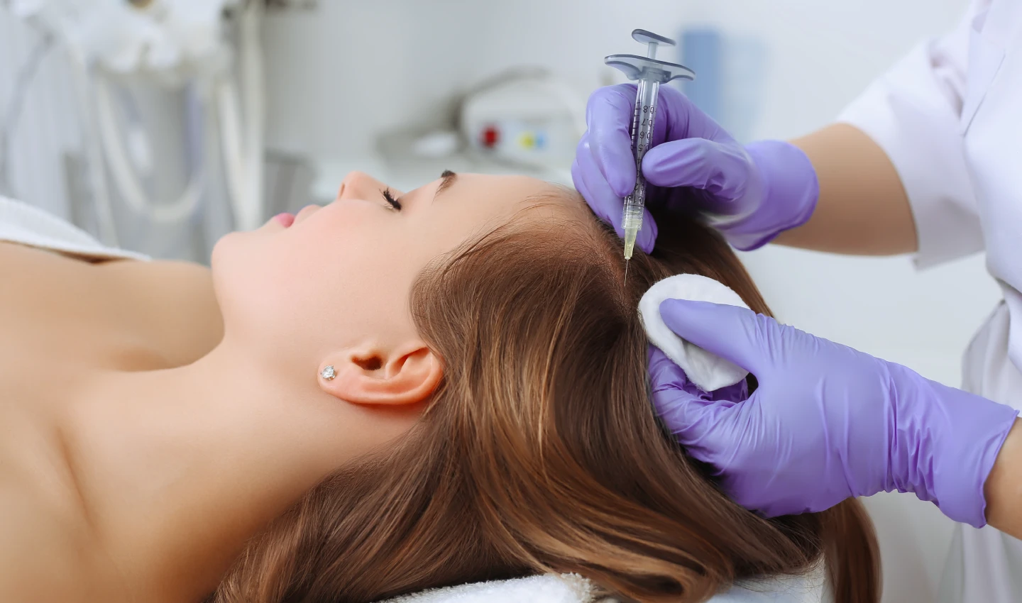 A person receiving a microneedling injection in her hair as part of a hair transplant procedure, demonstrating the benefits of combining microneedling and hair transplant surgery for thick, luscious locks.