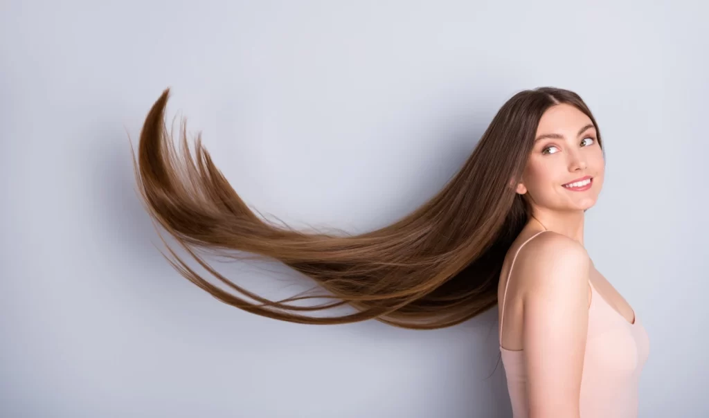 A person receiving various scalp treatments including hot oil treatment, scalp massage, and application of tea tree oil for optimal hair care.