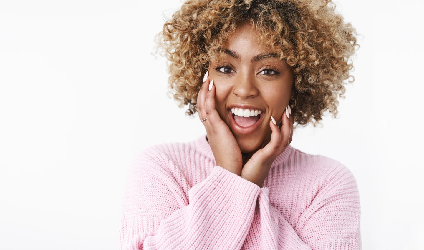 A happy young woman smiling confidently after affordable cosmetic dental surgery, demonstrating the positive impact of affordable dental costs on self-esteem.