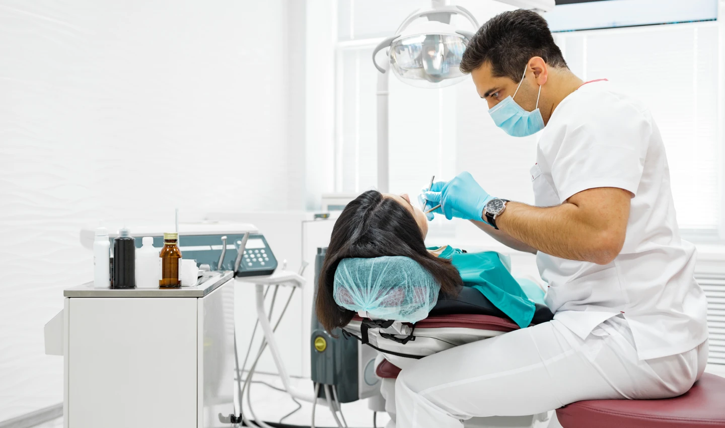 Expert cosmetic surgeon performing teeth beauty surgery on a patient, using advanced technology and techniques to reshape and resize teeth.