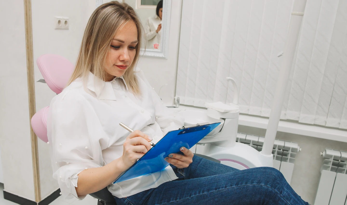 A woman holding a checklist titled "Teeth Cosmetic Surgery Checklist" as she prepares for her upcoming dental procedure.