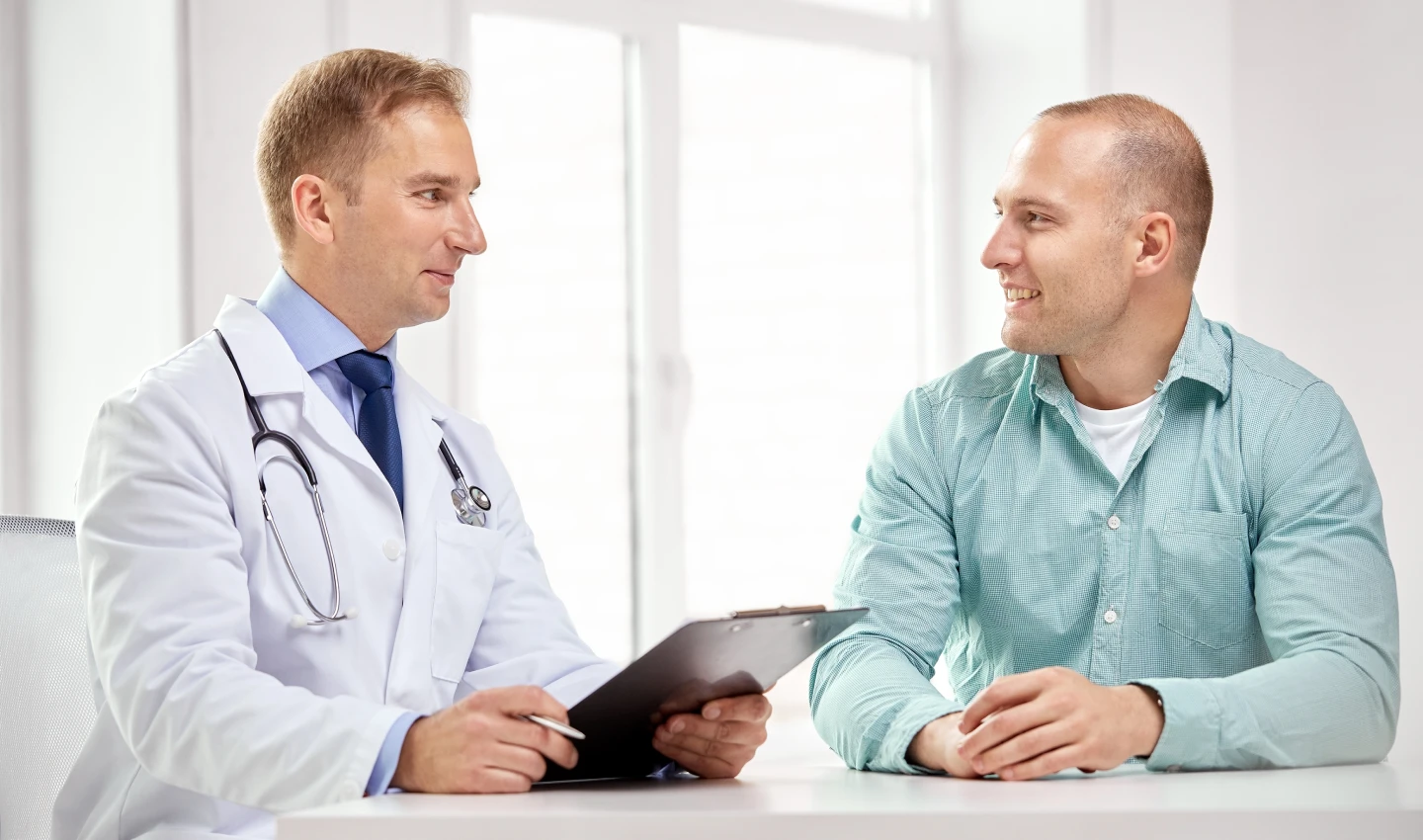 A patient and a doctor sitting in an office discussing financing options for hair restoration.