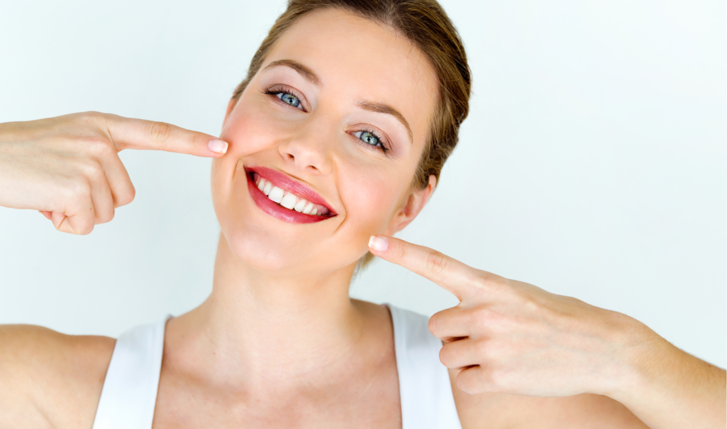 A woman laughing and showing a beautiful smile, demonstrating the rejuvenating effects of lip peels for achieving youthful and plump lips.