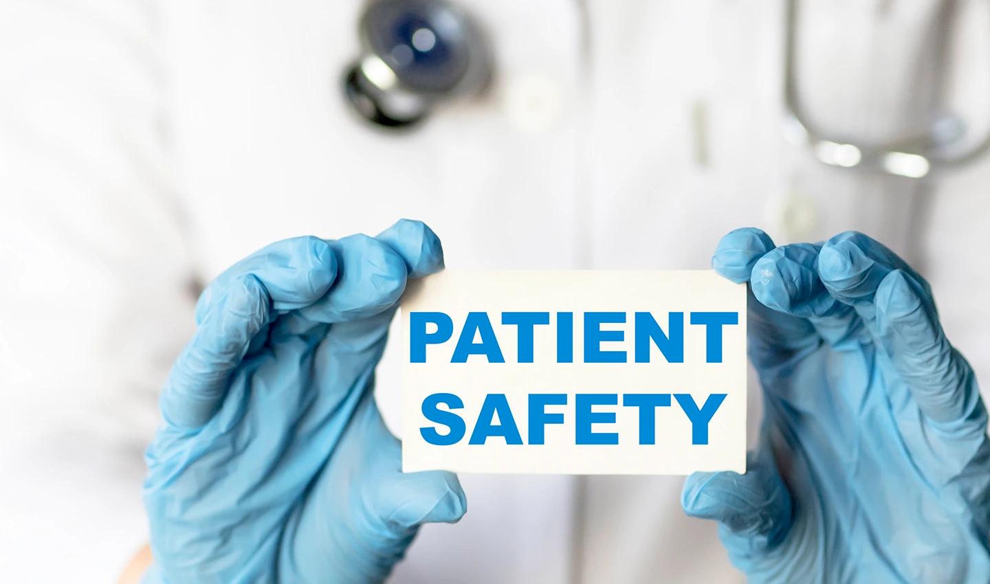 Facelift surgeon holding paper with 'Patient Safety' written on it, illustrating the importance of patient safety in facelift regulations.
