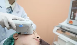 Woman receiving Ultherapy treatment on her face, with ultrasound technology being used to stimulate collagen production for lifted and tightened skin