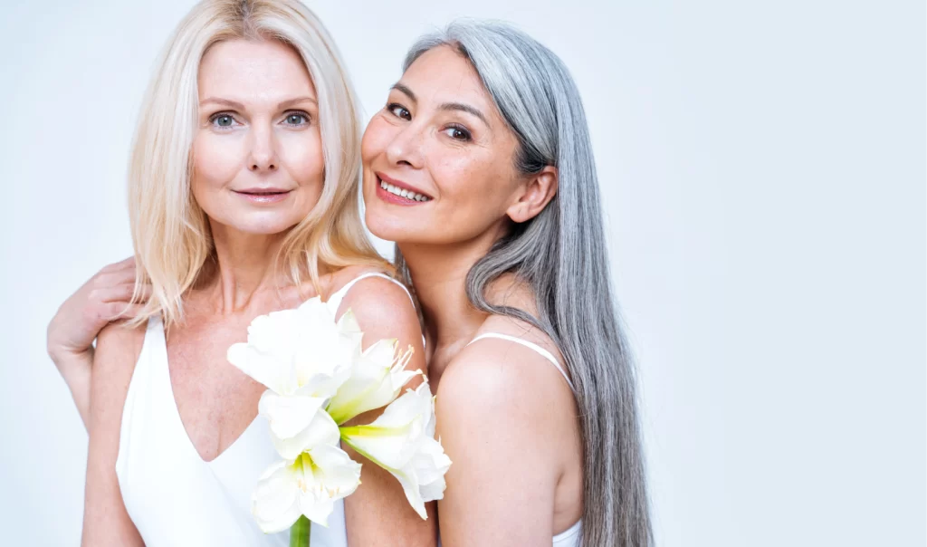 Two women with glowing skin smile after experiencing the power of oxygen facials.