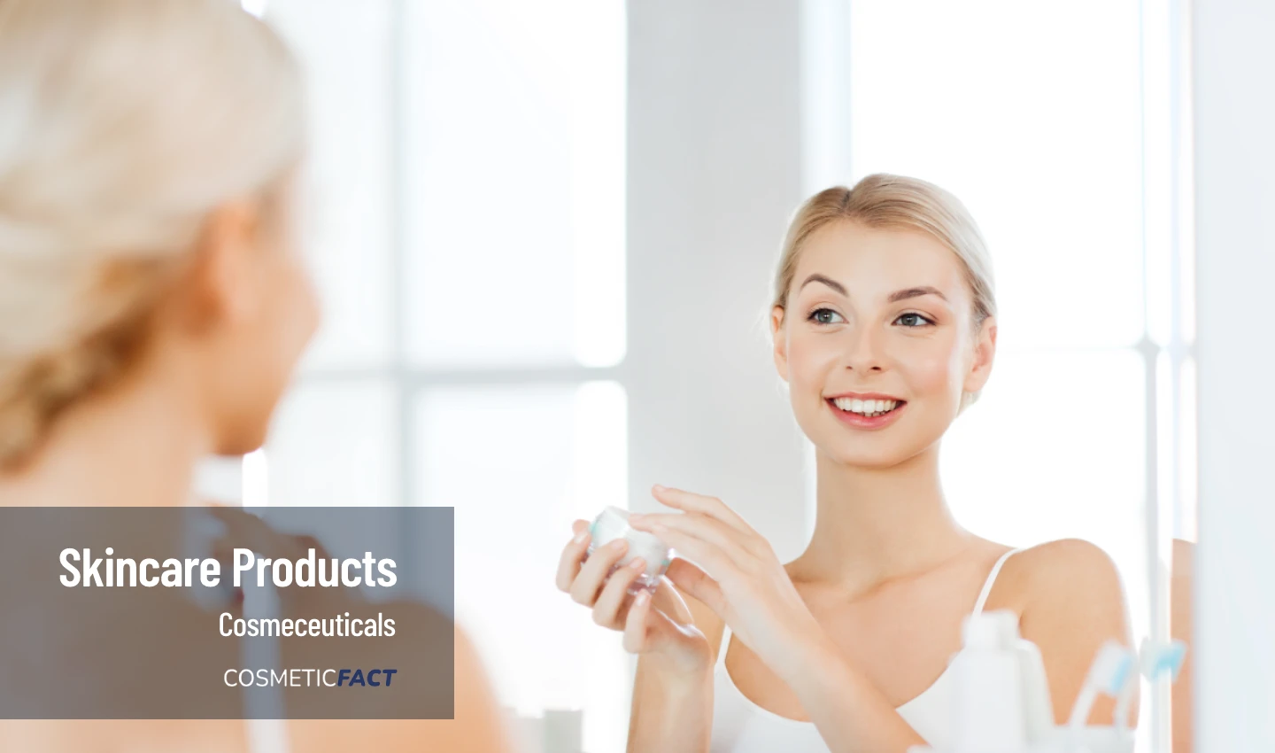 A woman looks at herself in the mirror after exfoliation skincare, showcasing a radiant complexion.