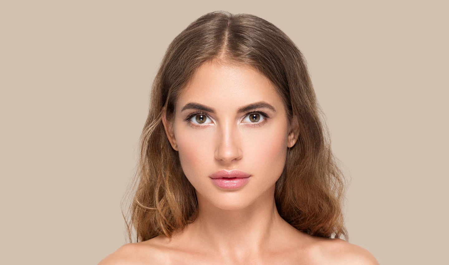 Image of a stunning young lady with a glowing skin and a fine jawline staring at the camera. The image represents the results that can be achieved by using Kybella to eliminate submental fat and achieve a desirable V-shaped face.