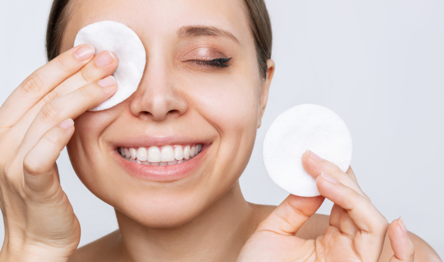 Happy woman using natural makeup remover for gentle and effective cleansing.