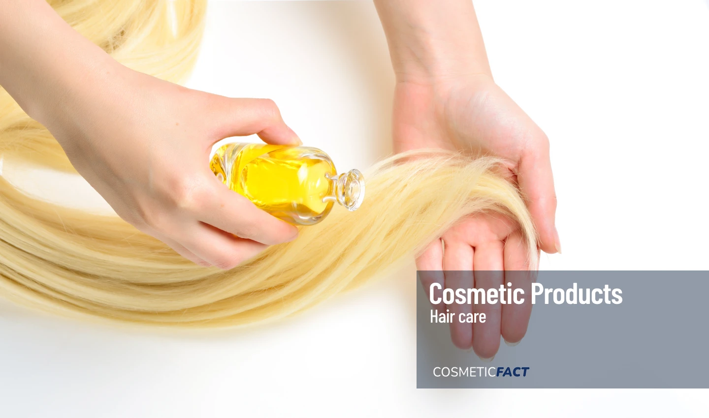 A person applying essential hair treatment to a bunch of hair in their hand.