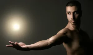 Visualization in Men's Body Care - An image of a muscular arm against a black background with a shiny spot in the background. The well-groomed arm suggests the importance of visualizing your body care routine for achieving desired results.