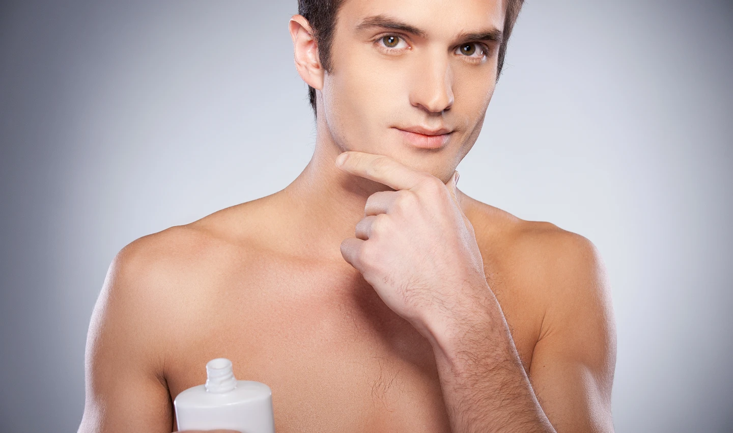 A man applies aftershave balm to his face after shaving to prevent irritation and moisturize his skin.