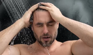 A man taking a cold shower, promoting men's cold showers for perfect skin.