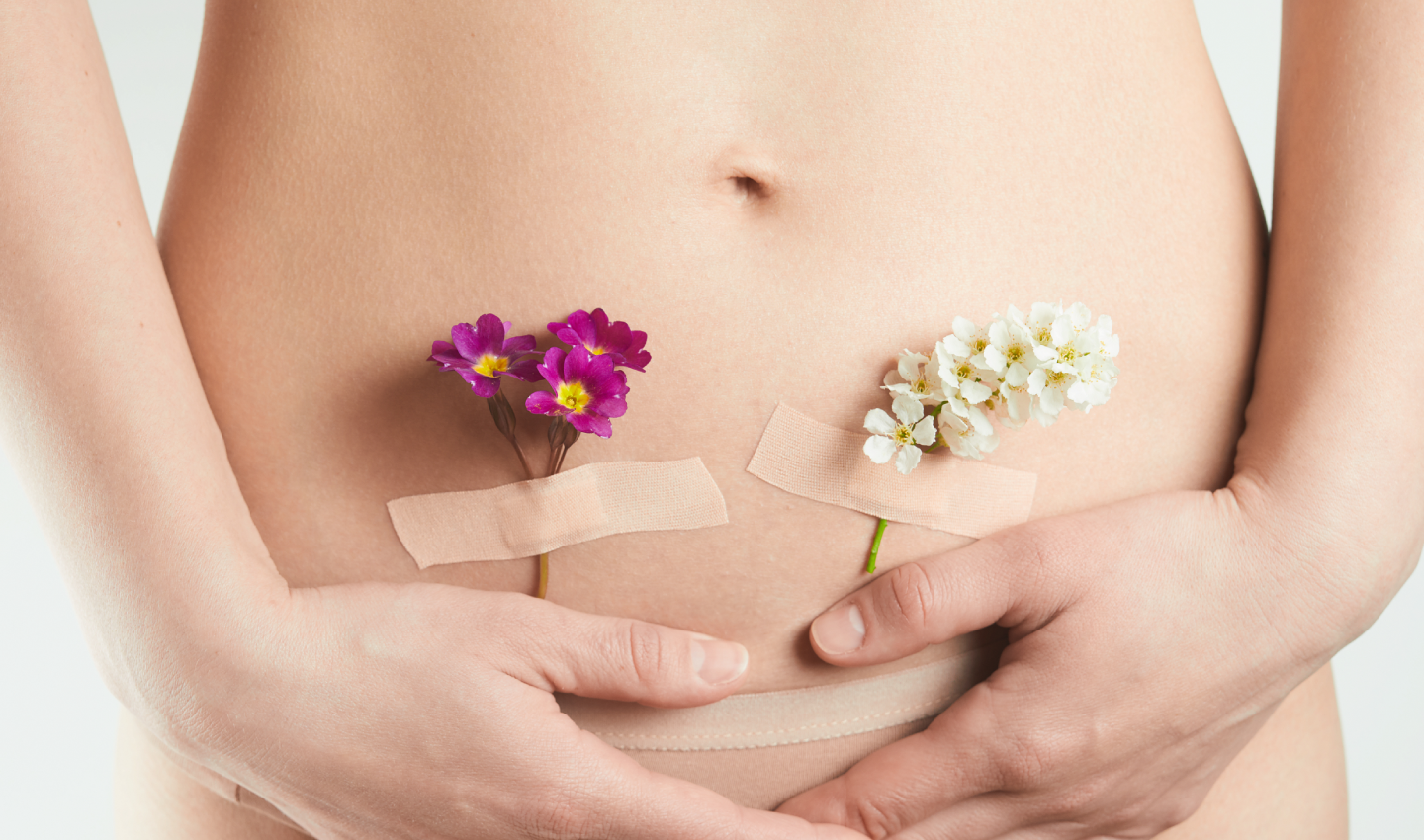 Image of a woman with a flower on her tummy, after undergoing postpartum cellulite treatments to restore her confidence.