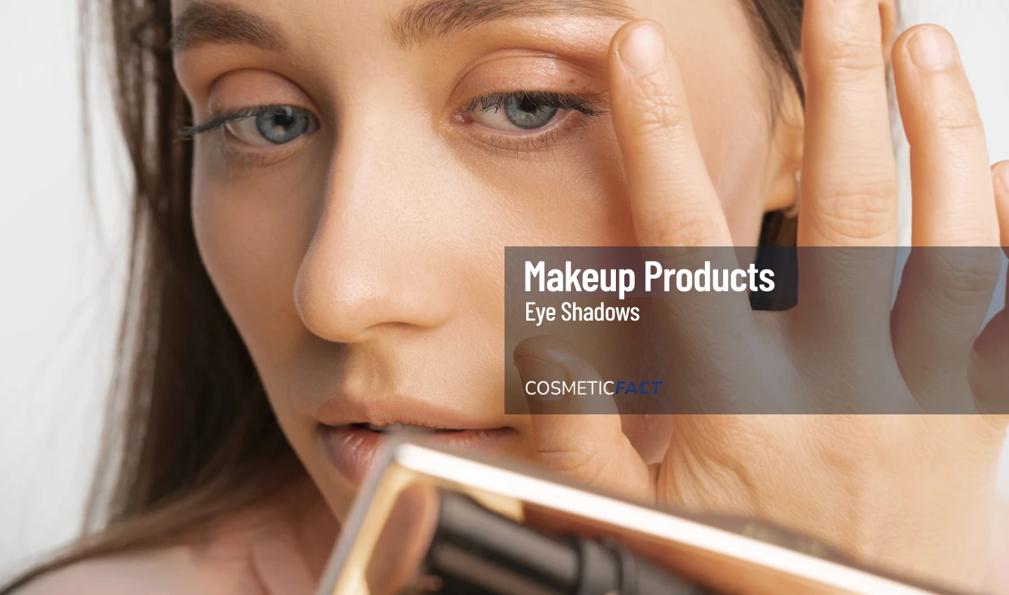 A woman with glowing skin applying a nude-colored eye shadow with her index finger above her eyes, showcasing the ease and simplicity of using neutral eye shadow palettes to create an effortlessly elegant eye makeup look.