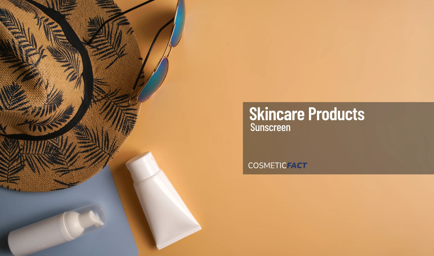 A hat, sunglasses, and various skin care lotions displayed together, highlighting the importance of using sunscreen year-round.