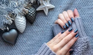 A hand with manicured nails and winter sleeves, emphasizing the importance of nail care tips for cold weather.
