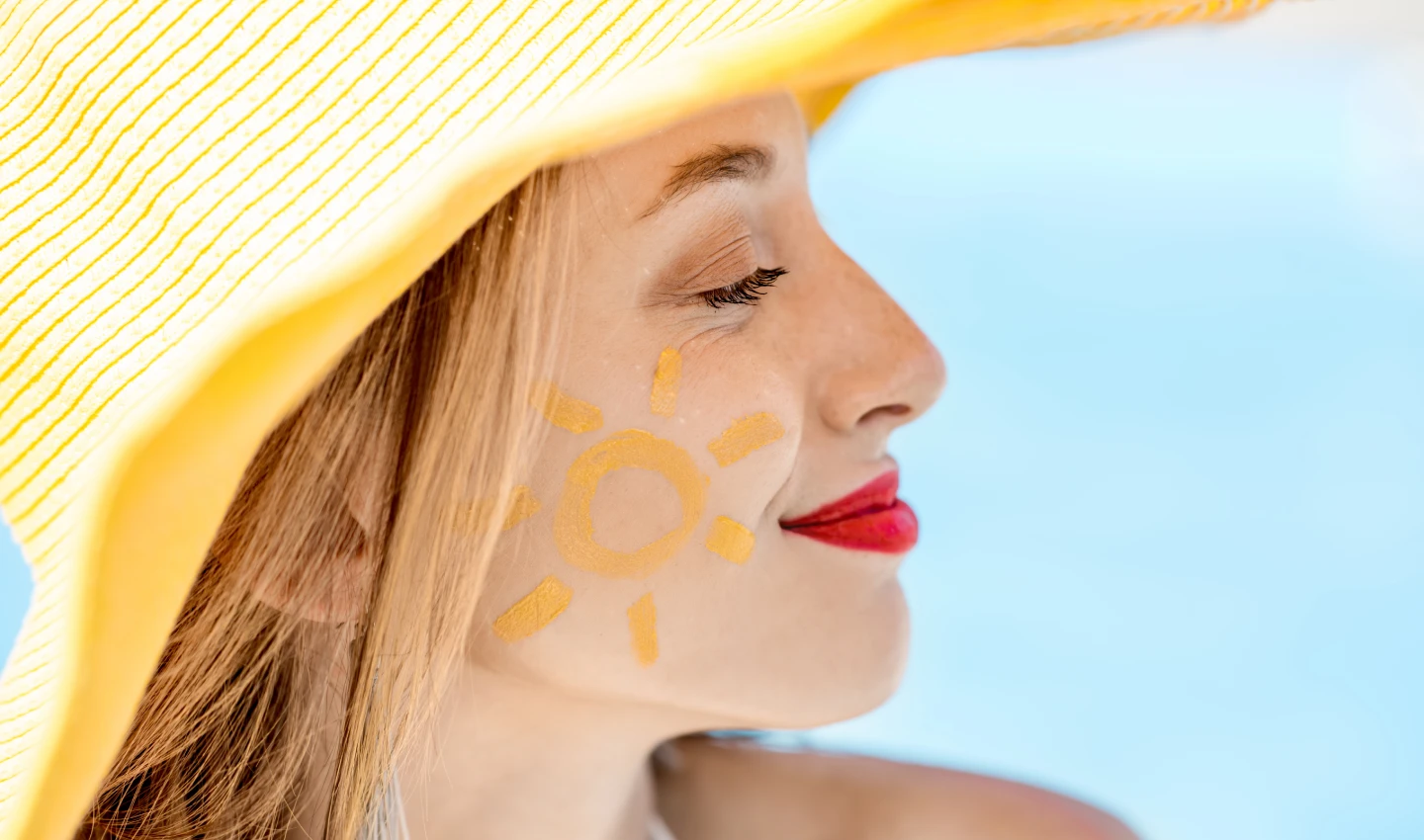 Woman smiling at the beach with Smart Face Sunscreen protection.