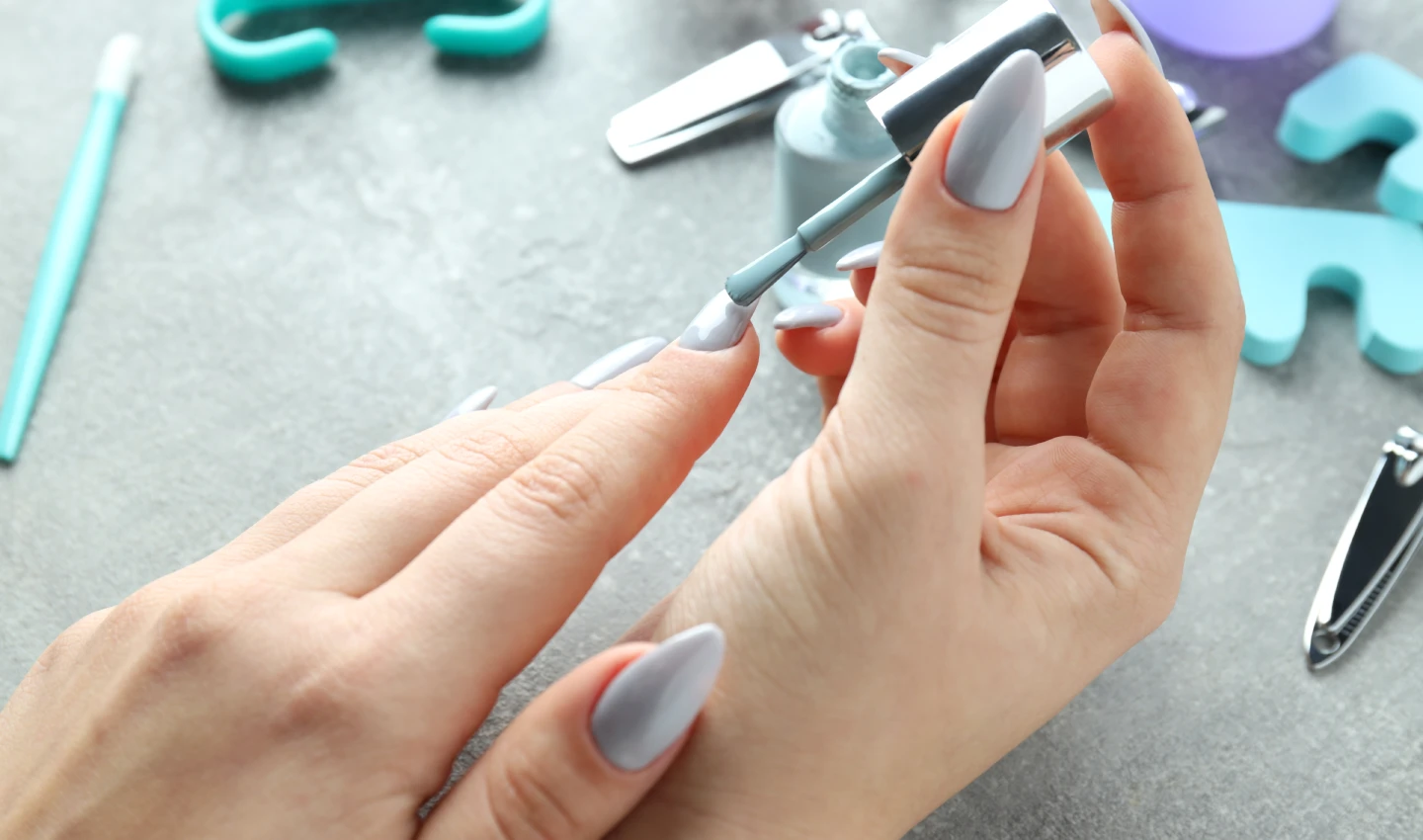 Woman using an innovative nail care tool to apply nail polish for effortless and healthy nails.
