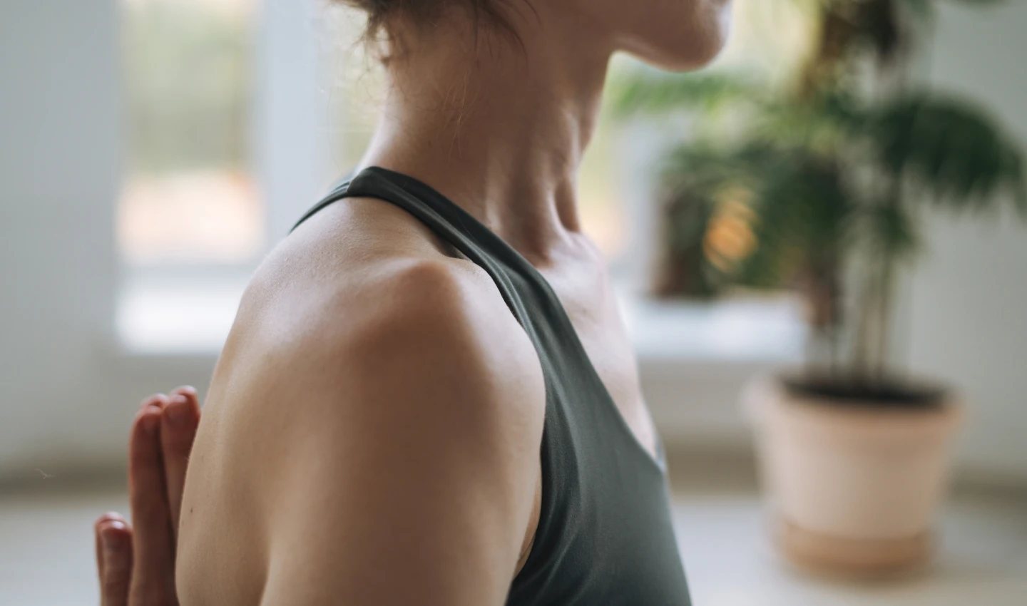 Woman performing neck yoga exercise, standing with a straight neck.