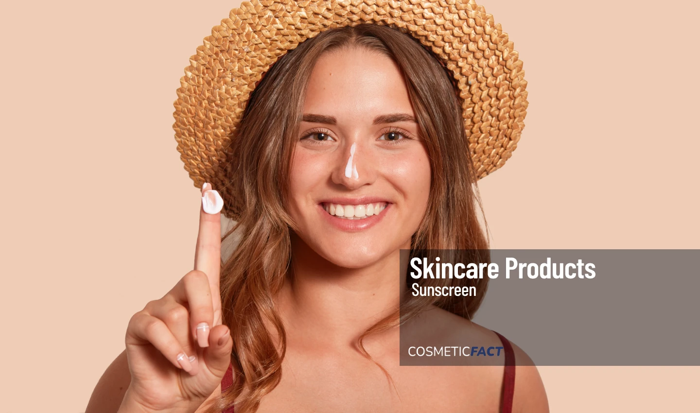 Woman applying sunscreen on her face with a smile, demonstrating the importance of choosing the right sunscreen for your skin type.