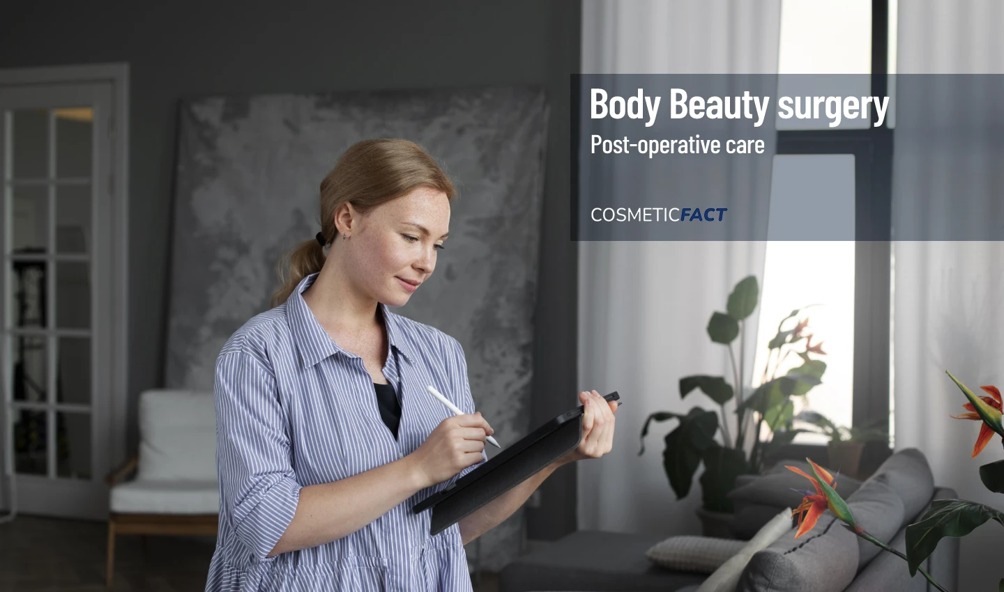 A woman sits at a table with a laptop, recovering at home after body surgery while following a comprehensive recovery guide.