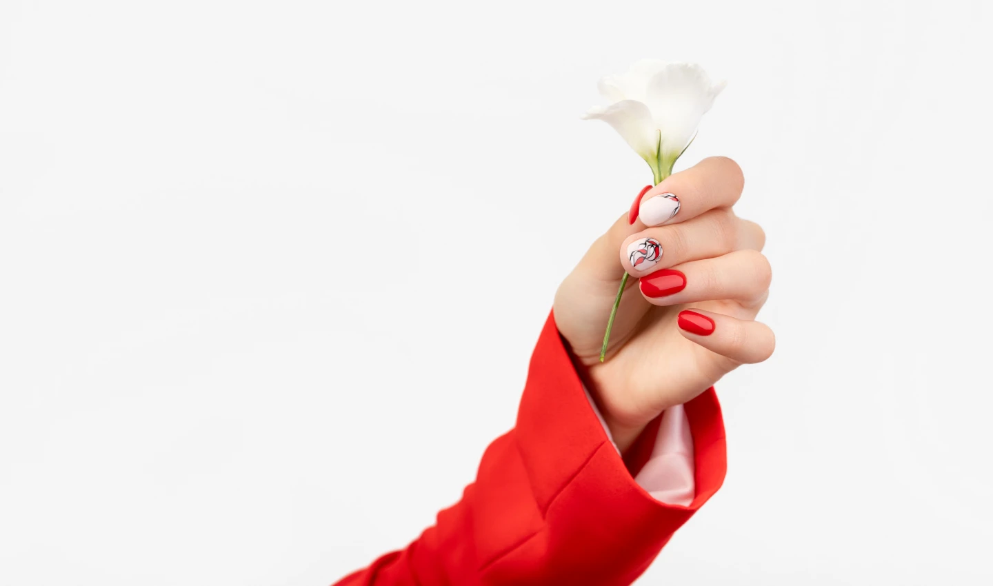 A beautiful hand holding a flower showcasing dazzling nail designs.