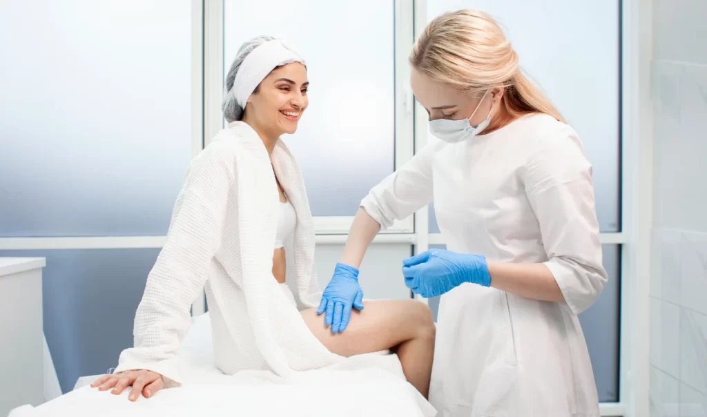 Doctor applying lotion on patient's legs as part of non-surgical cellulite treatment.