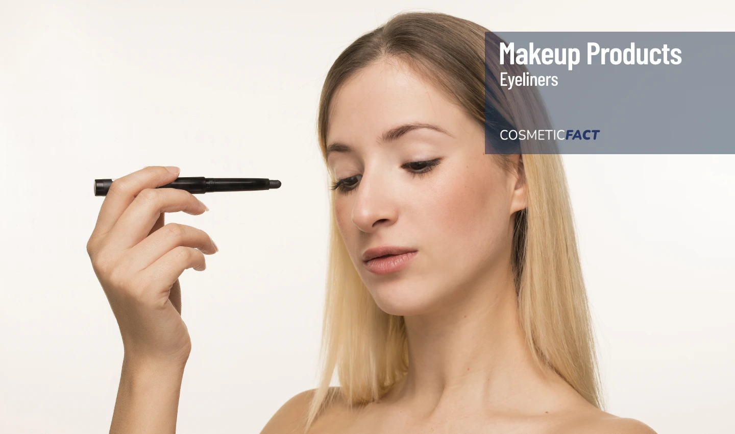 A young woman applying eyeliner with an eyebrow pencil, showcasing the importance of using the right tools and techniques to achieve long-lasting eyeliner that stays put all day.