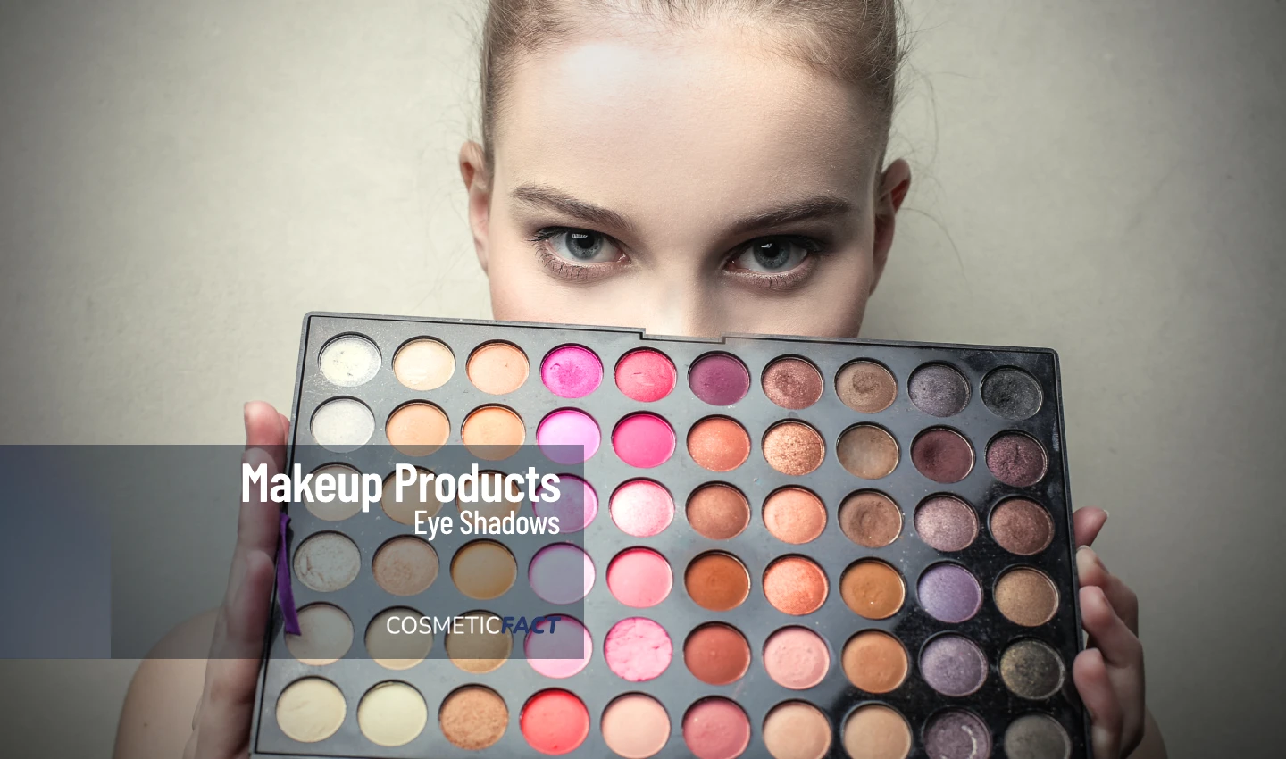 A young lady holding a large palette of versatile eye shadows with a wide range of colors, perfect for creating stunning and versatile makeup looks suitable for any occasion.