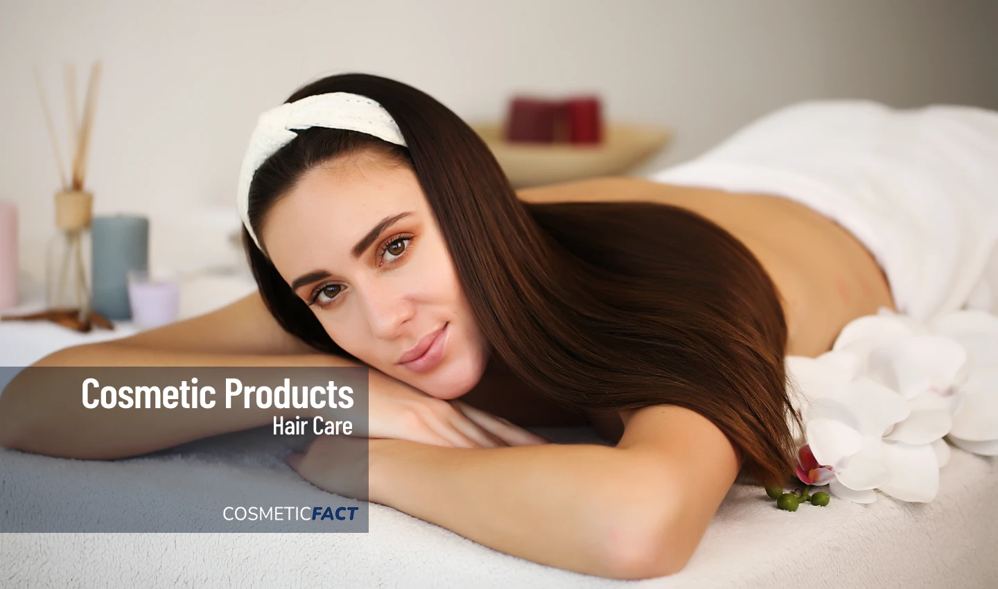 Woman with long, silky hair and a cream headband smiling at the camera, enjoying the benefits of indulgent hair treatments for healthy, happy hair.