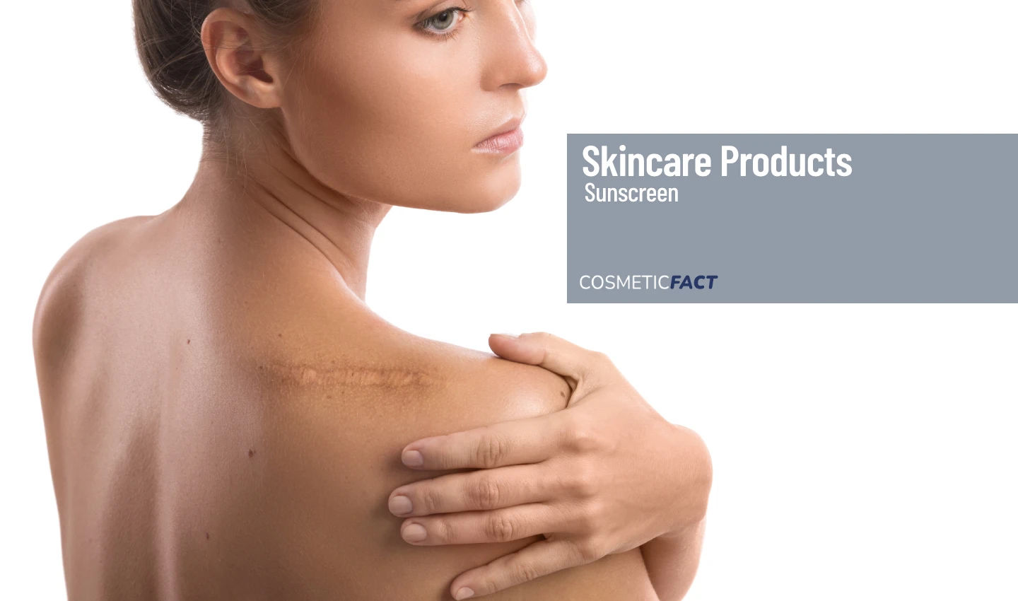 A woman pointing to a scar of sunburn on her shoulder, demonstrating the importance of sunscreen in preventing skin cancer.