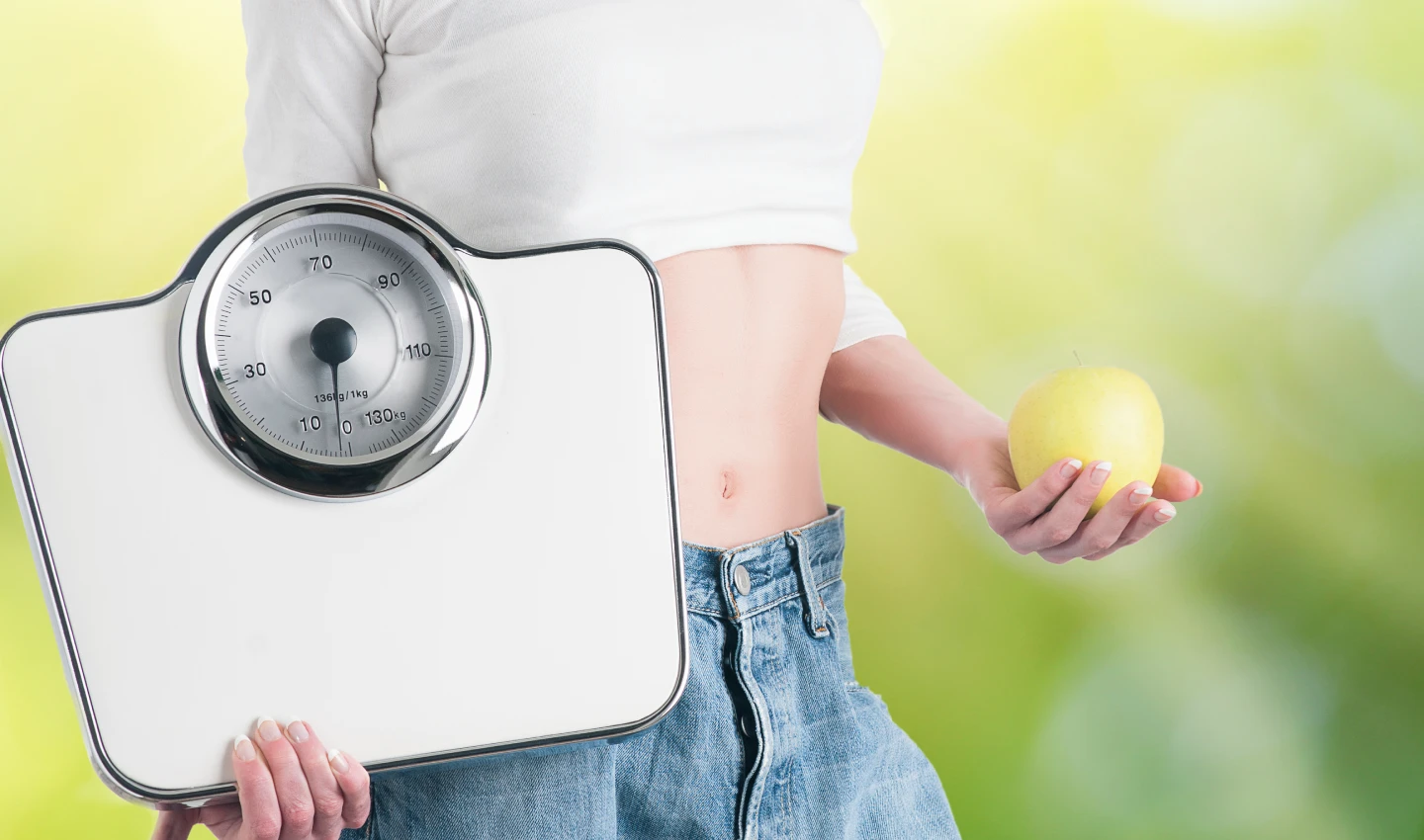 Image of a weight scale next to a person who has undergone body cosmetic surgery and weight loss procedures, emphasizing the importance of realistic expectations and commitment to a healthy lifestyle.