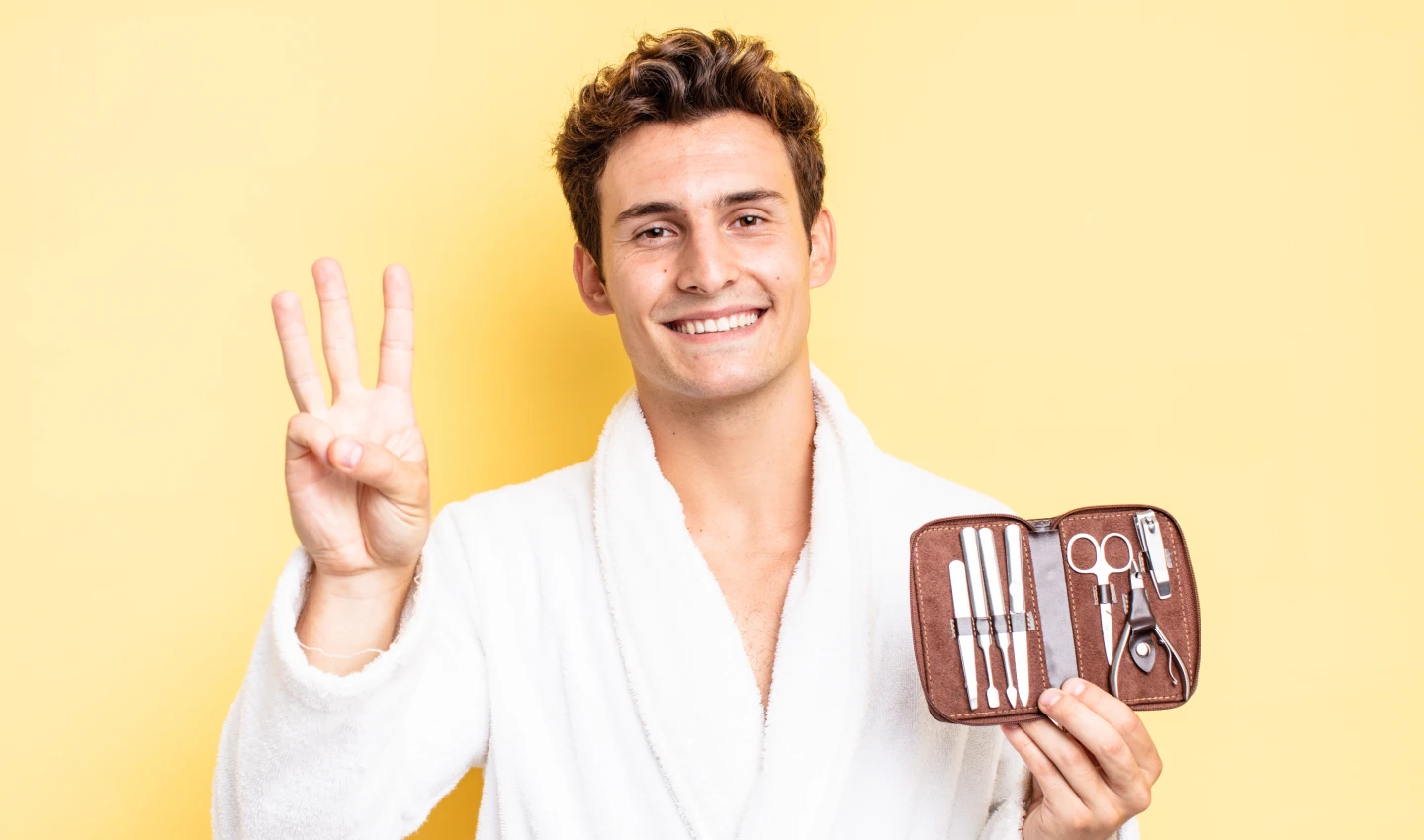 Mindful Body Care for Men - An image of a young man wearing a white bathrobe and holding a grooming set in his hand. The man's happy expression suggests the benefits of prioritizing self-care through mindful body care practices. The image emphasizes the importance of incorporating mindfulness into your body care routine, from using natural products to practicing self-awareness and relaxation.